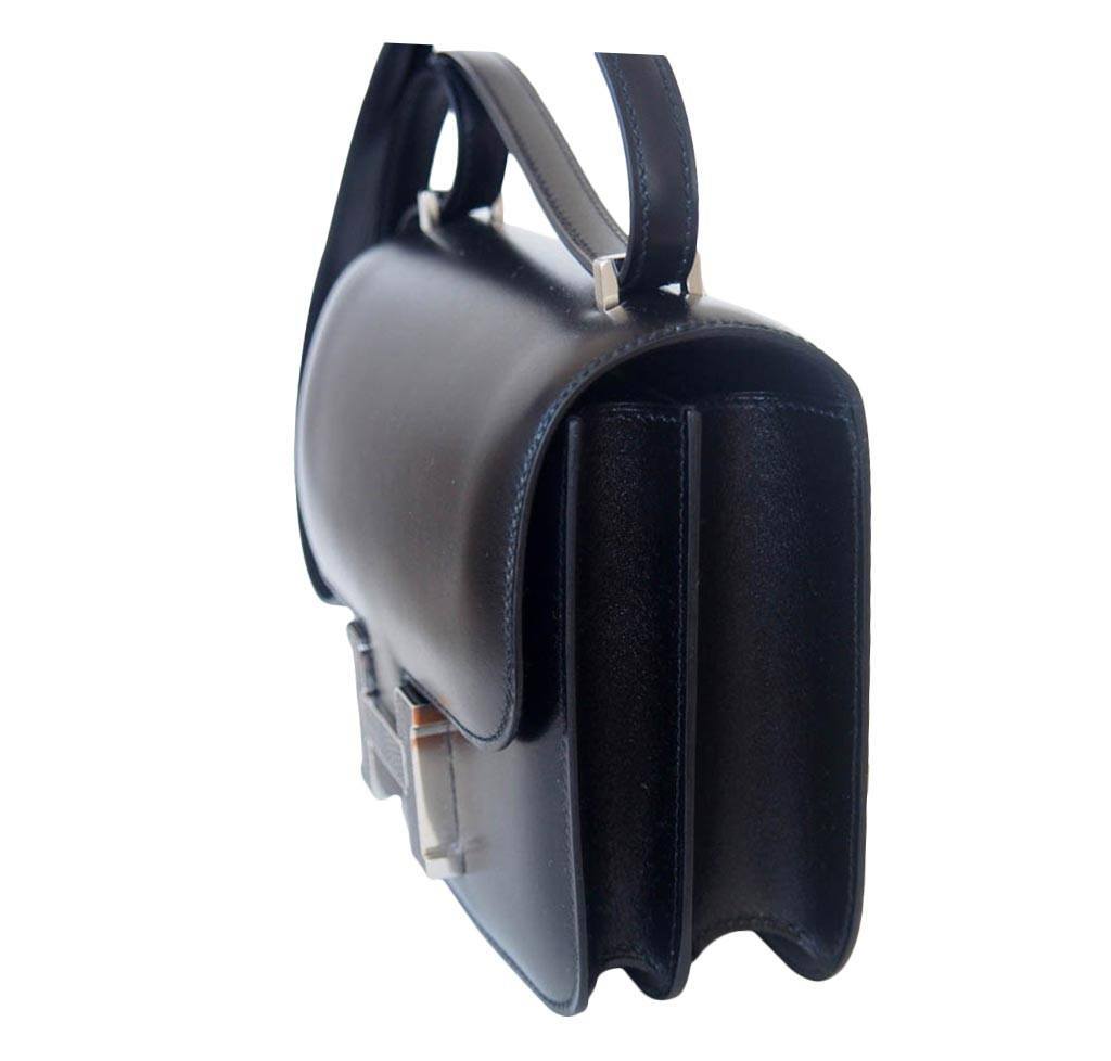 Black handbag with a silver clasp on a white background