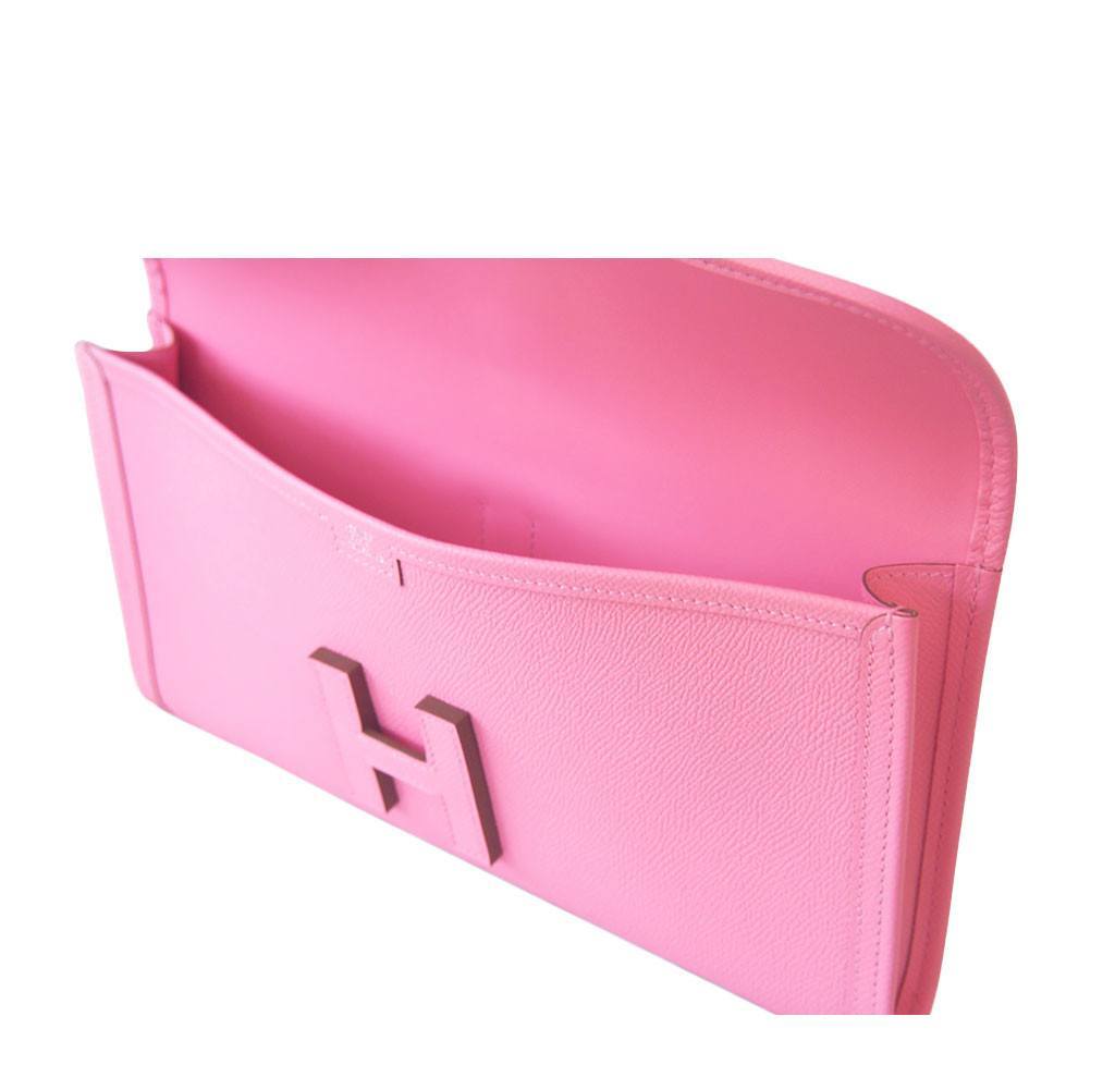 Pink clutch bag with a logo on a white background