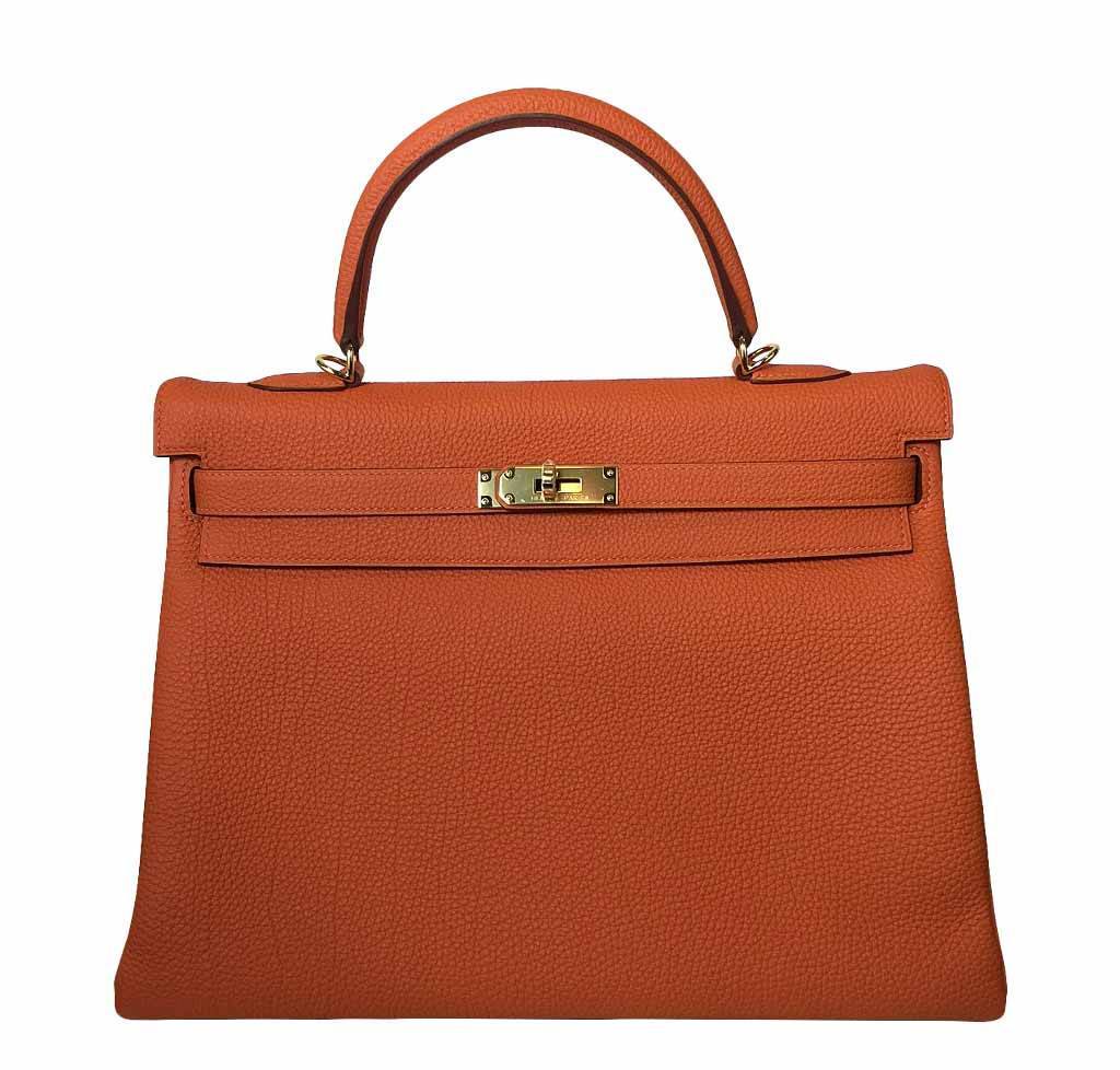 Orange handbag with gold hardware on a white background