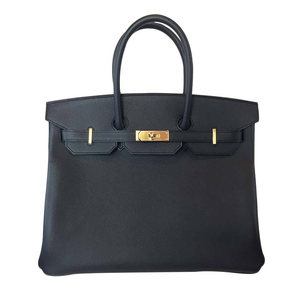 Black handbag with gold hardware on a white background
