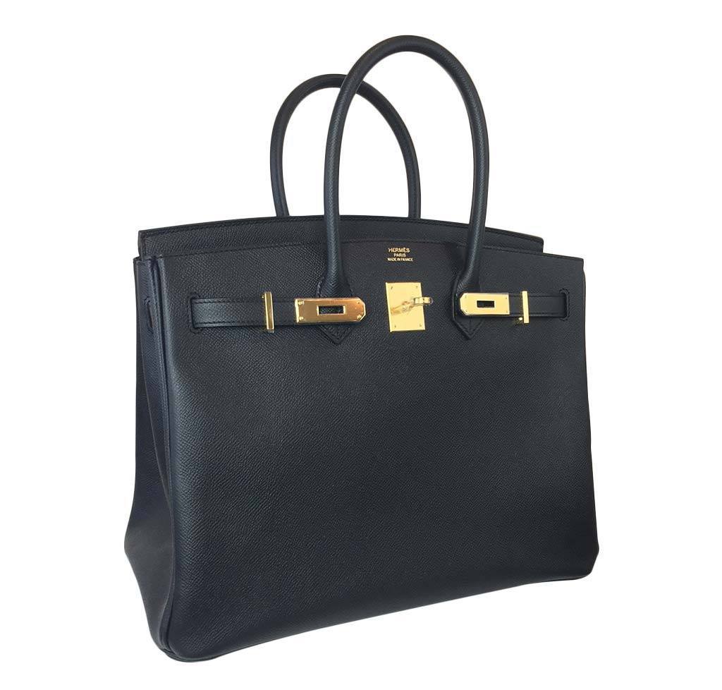 Black handbag with gold hardware on a white background