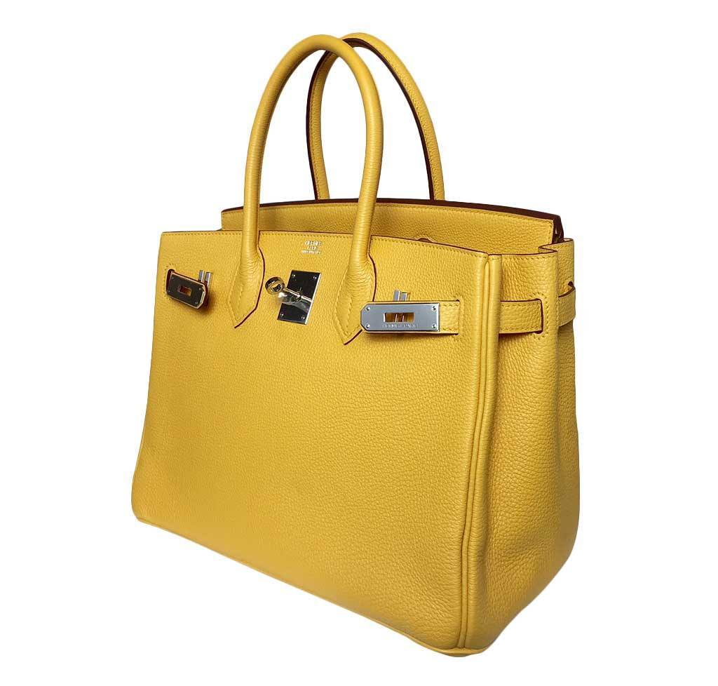 Yellow handbag with silver hardware on a white background