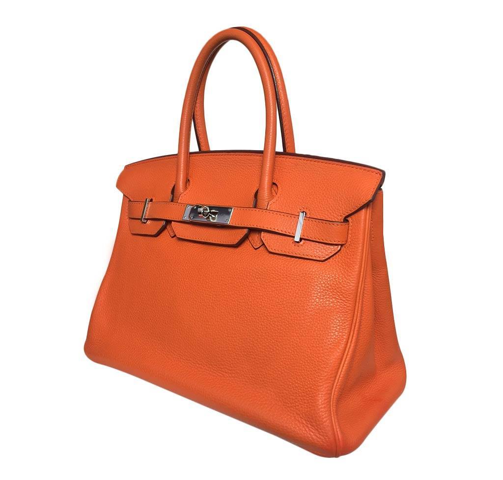 Orange handbag with silver hardware on a white background