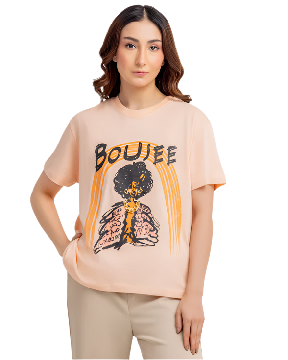Woman wearing a beige t-shirt with a graphic design on a white background