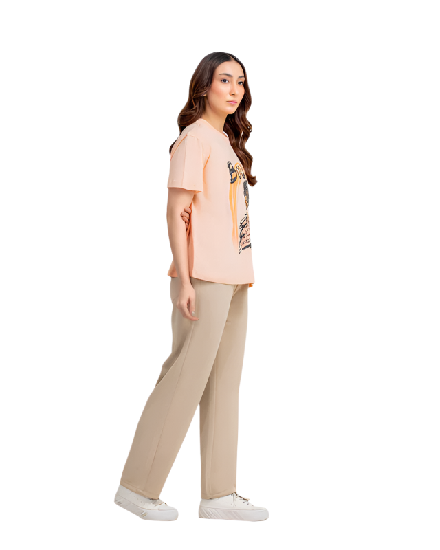 Woman wearing a light pink t-shirt and beige pants on a white background