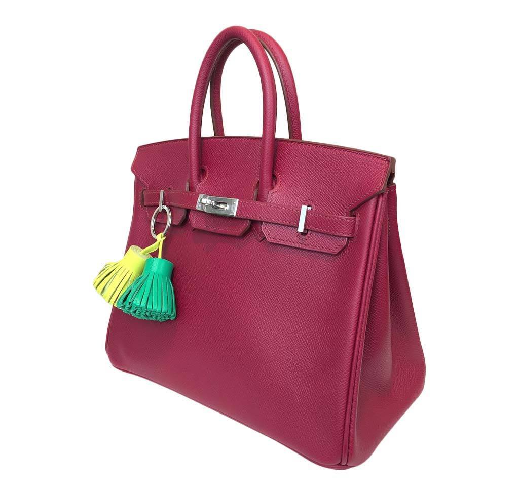 Pink handbag with a colorful tassel on a white background