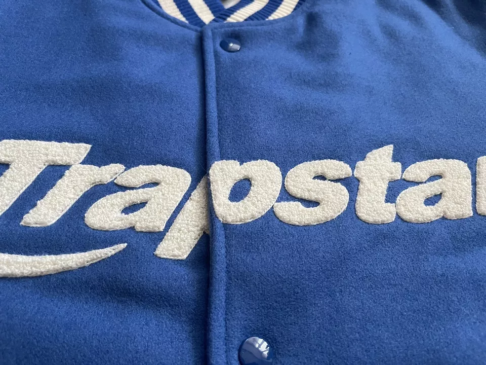 Blue jacket with 'Trapstar' logo in white on a close-up view