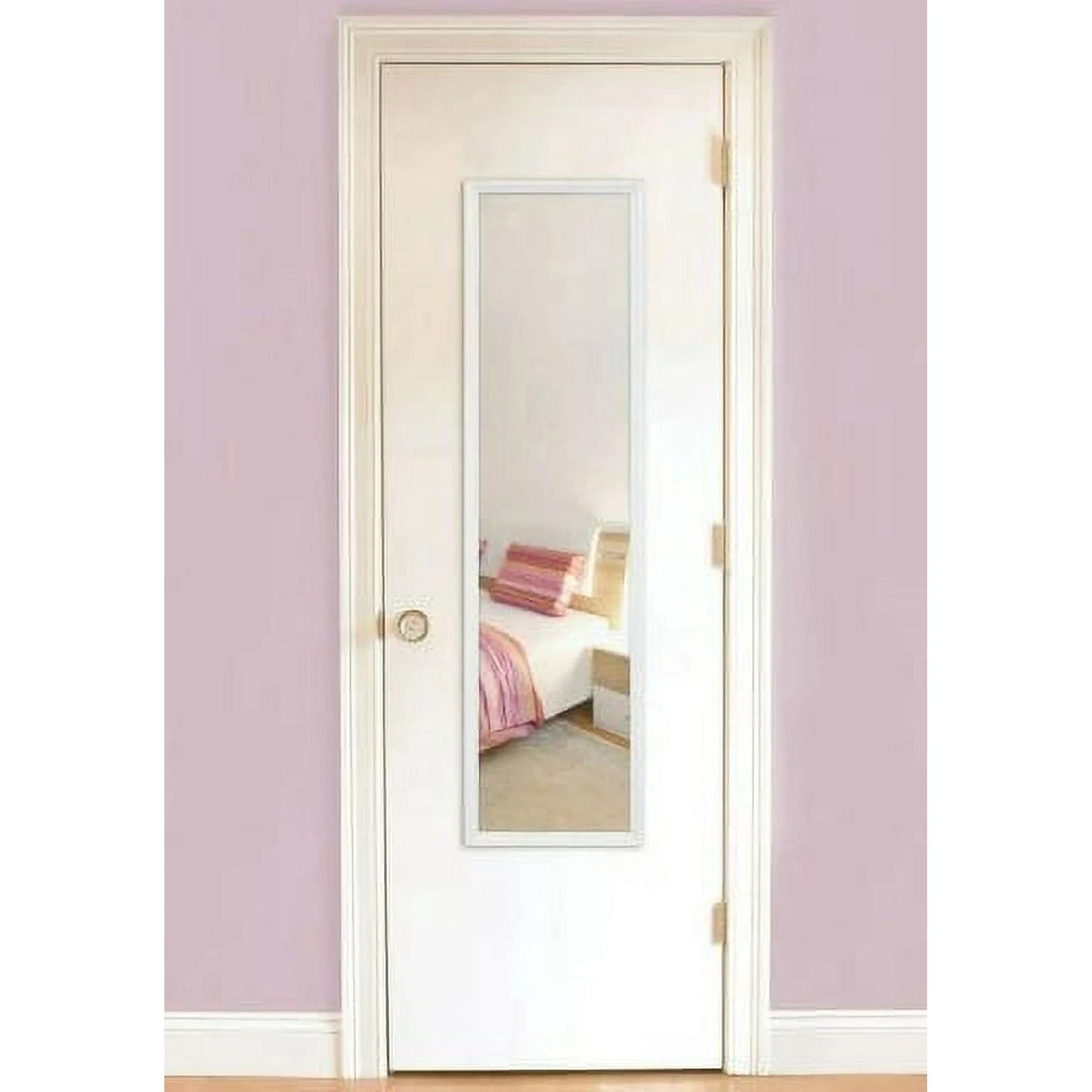 White door with a mirror panel in a room with pink walls and a bed.