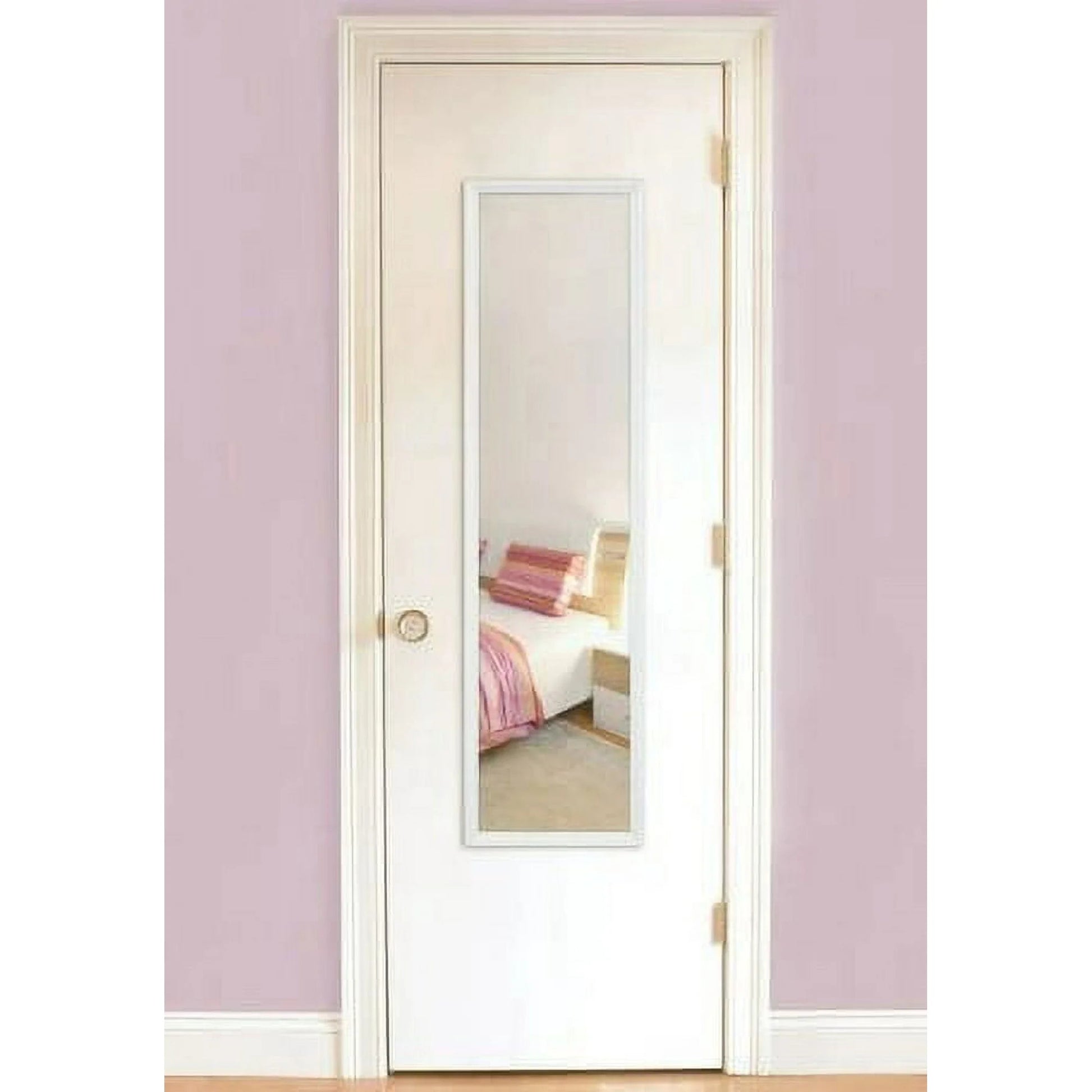 White door with a mirror panel in a room with pink walls and a bed.