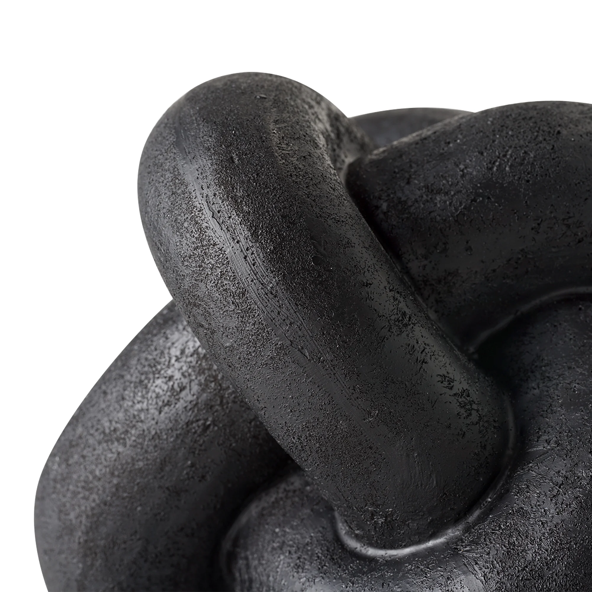 Close-up of a black metal knot sculpture on a white background